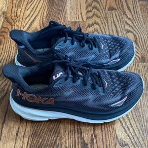 Women’s black/gold Hoka Clifton 9 running shoes, size 8. Good used condition